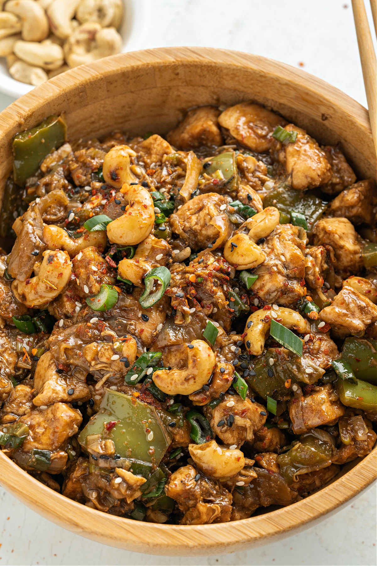 Cashew chicken in a wooden serving bowl.