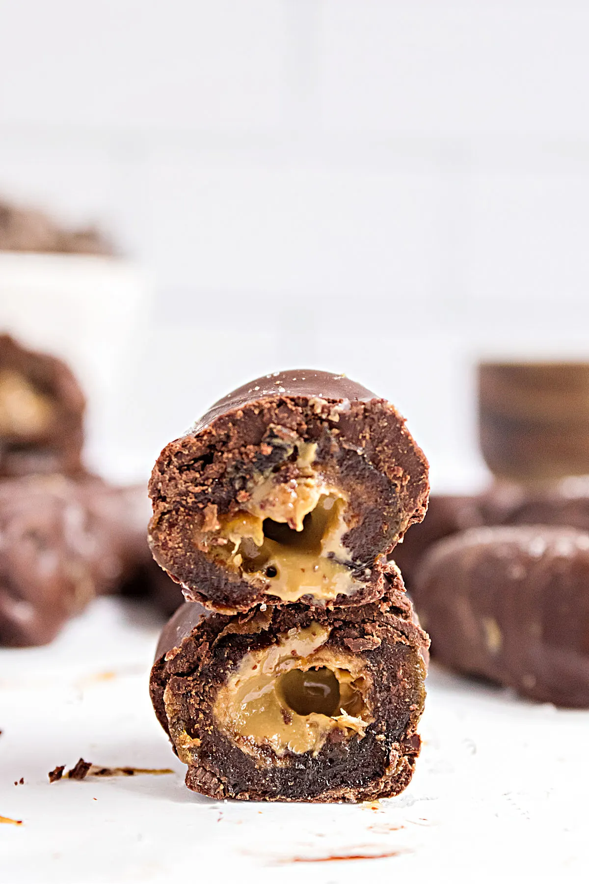 Chocolate covered date with peanut butter cut in half to reveal filling.