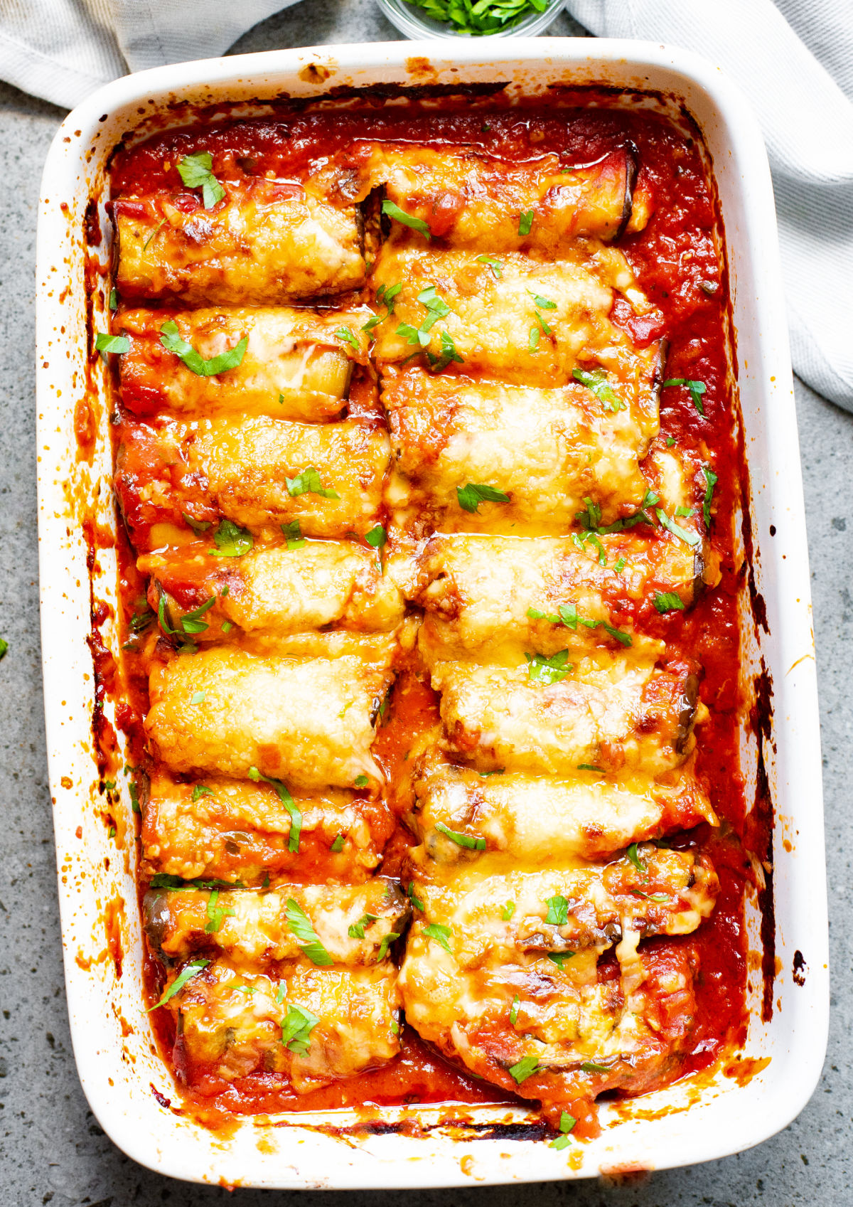 Eggplant rollatini assembled and baked in a 13x9 dish.