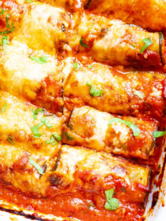This Eggplant Rollatini is low carb take on the classic Italian meal. Strips of eggplant are rolled with a cheesy garlic filling, then baked with marinara sauce for an easy meatless keto dinner idea!